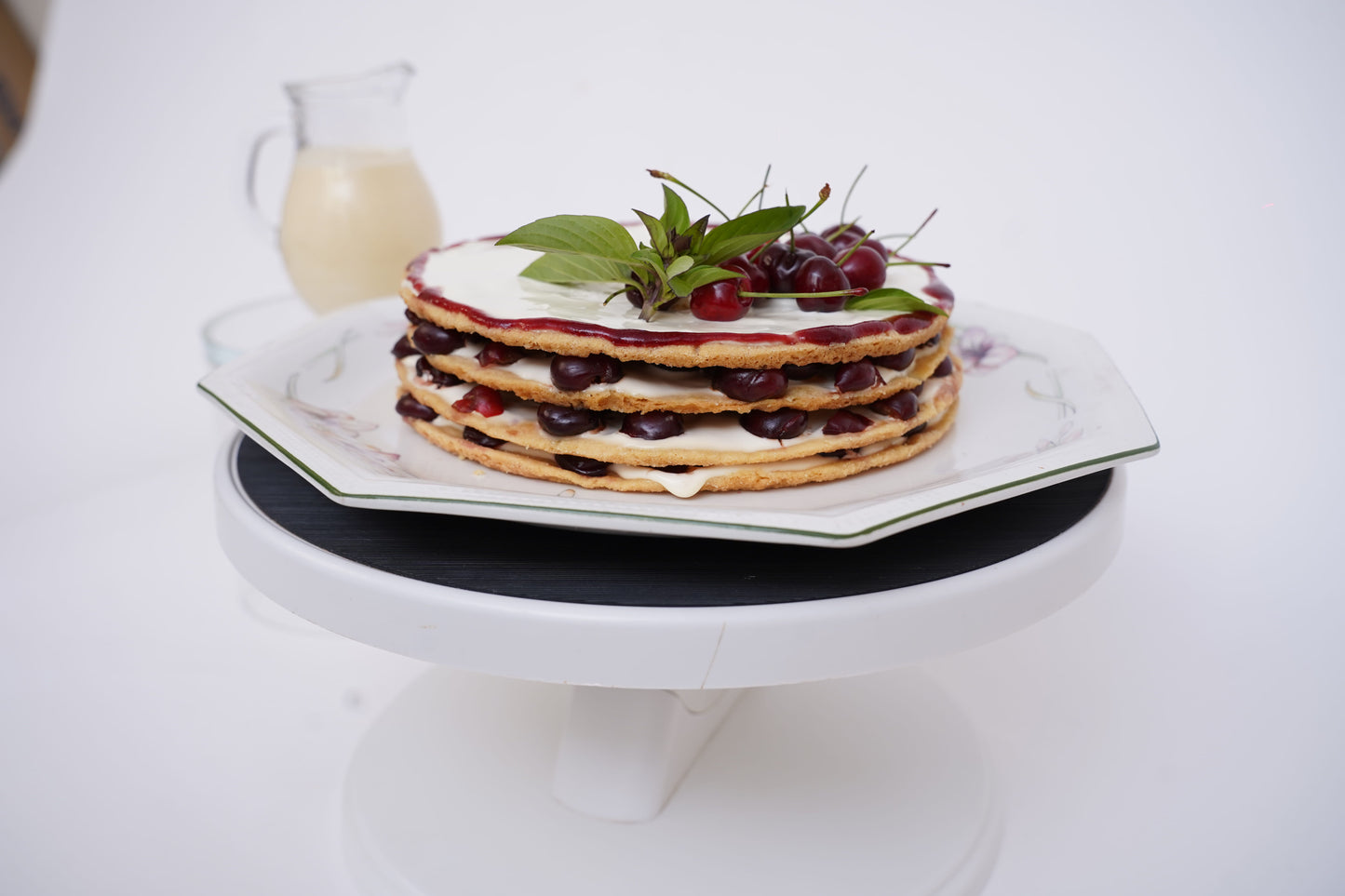 Cherry Shortbread Dessert: Layers of buttery shortbread biscuit, lathered with fresh cream and juicy cherries, topped with a beautifully arranged cherry layer and a delicate caramel web. Served with a box of homemade custard for an extra touch of indulgence.